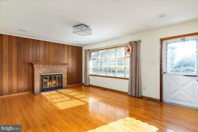 a view of an empty room with a fireplace and a window
