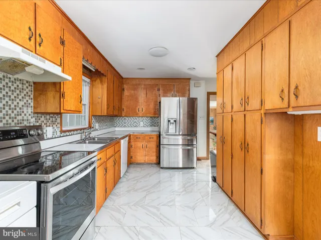 a kitchen with stainless steel appliances granite countertop a refrigerator a sink dishwasher with a stove and refrigerator