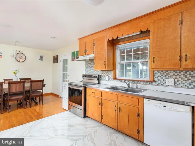 a open kitchen with granite countertop a sink stove and cabinets