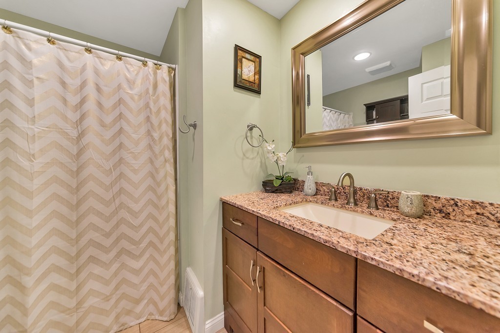 48 Drexel Street Springfield, MA 01104 - Photo 6 of 24 a bathroom with a granite countertop sink and a mirror