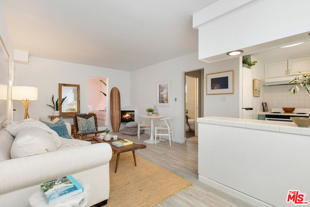 a living room with furniture a table and kitchen view