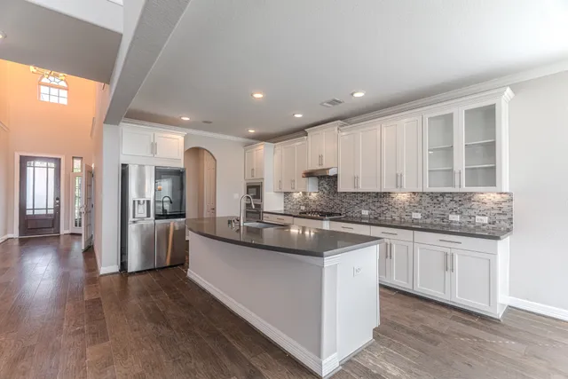 a kitchen with stainless steel appliances granite countertop a sink stove and refrigerator