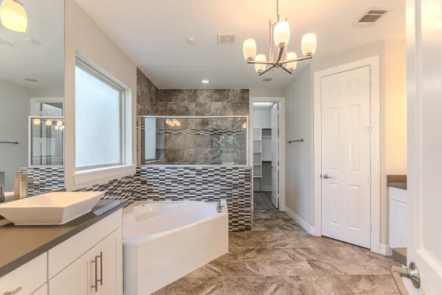 a spacious bathroom with a granite countertop sink a mirror and shower