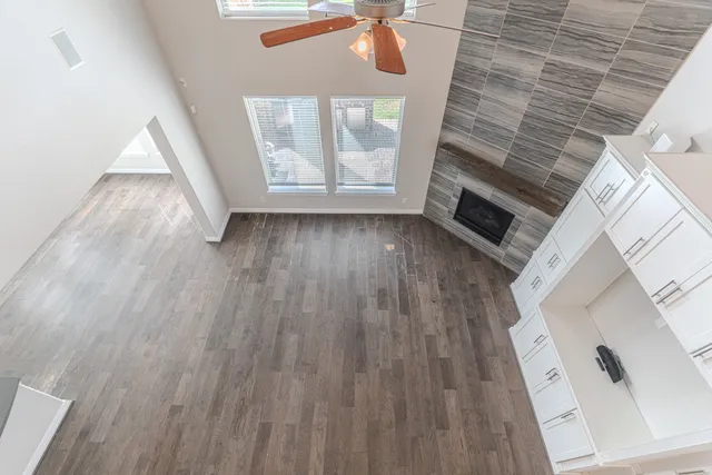 an empty room with windows and chandelier fan