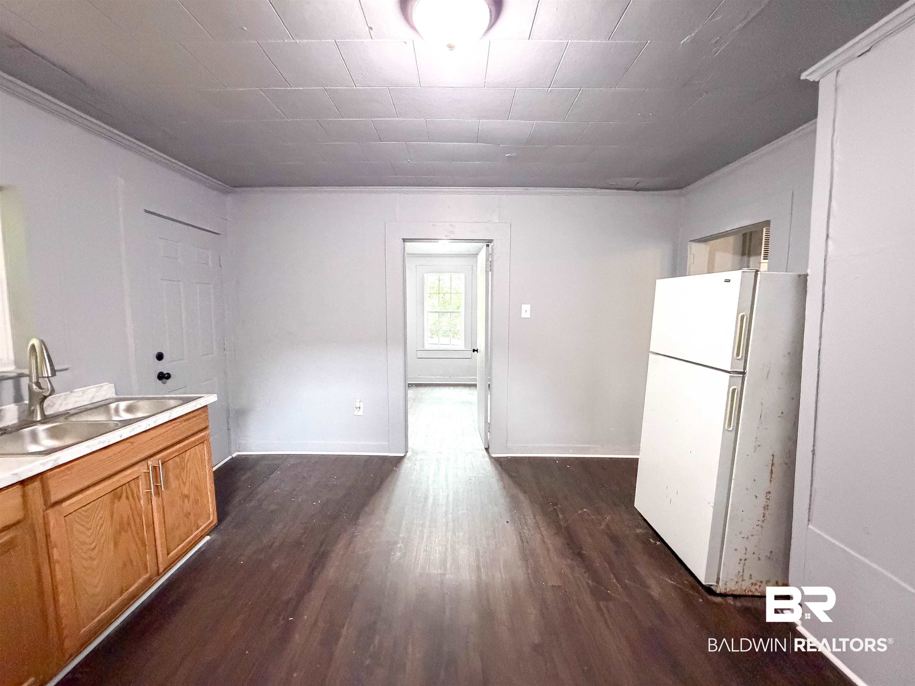 38 Flock Avenue Mobile, AL 36610 - Photo 10 of 27 Kitchen area featuring wood-finish flooring, light gray walls, a ceiling light fixture, and a window with natural light