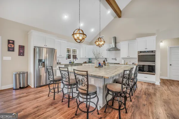 a kitchen with a dining table chairs cabinets and a window