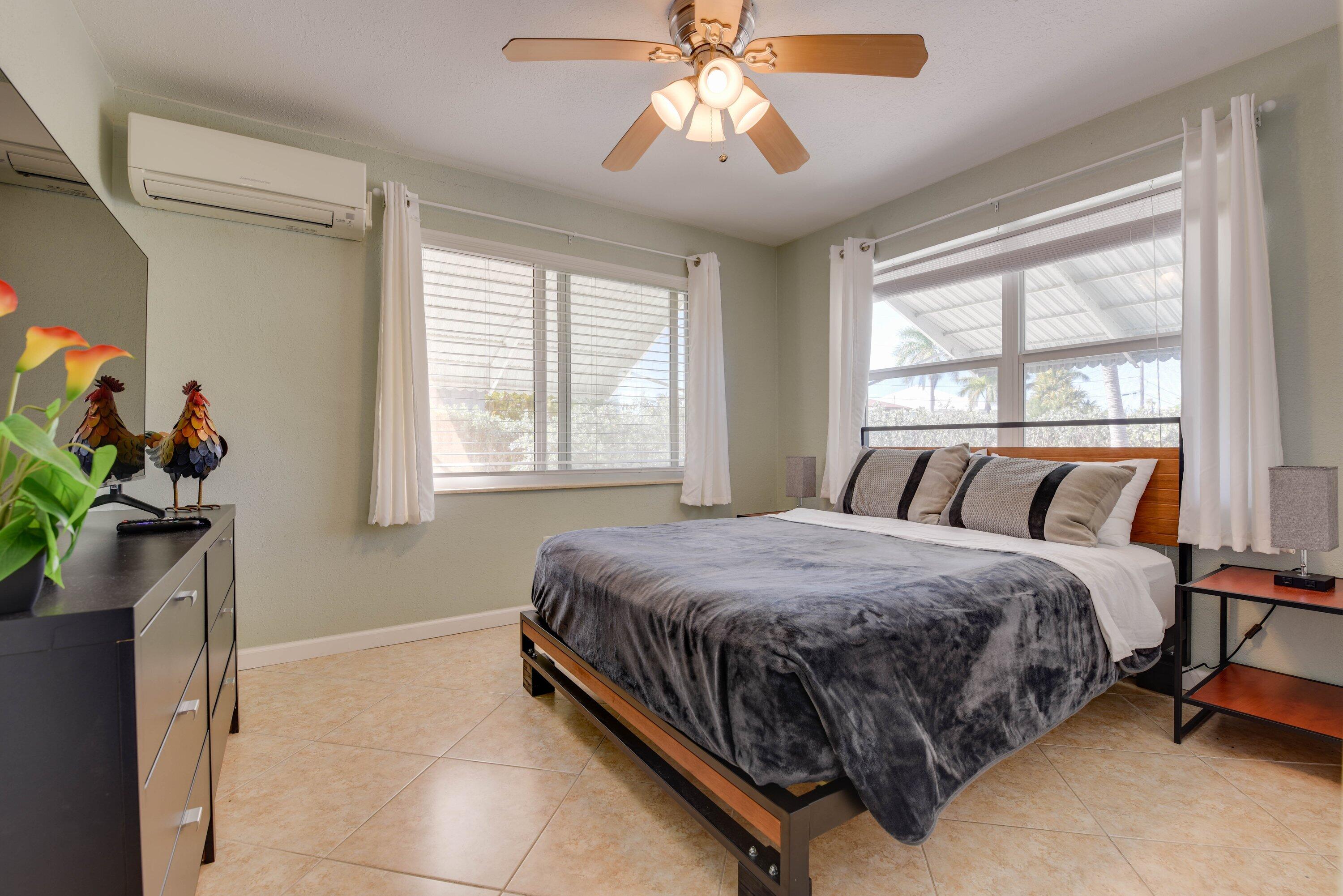 1567 Watson Boulevard Big Pine Key, FL 33043 - Photo 21 of 57 a bedroom with a bed potted plant on table and a window