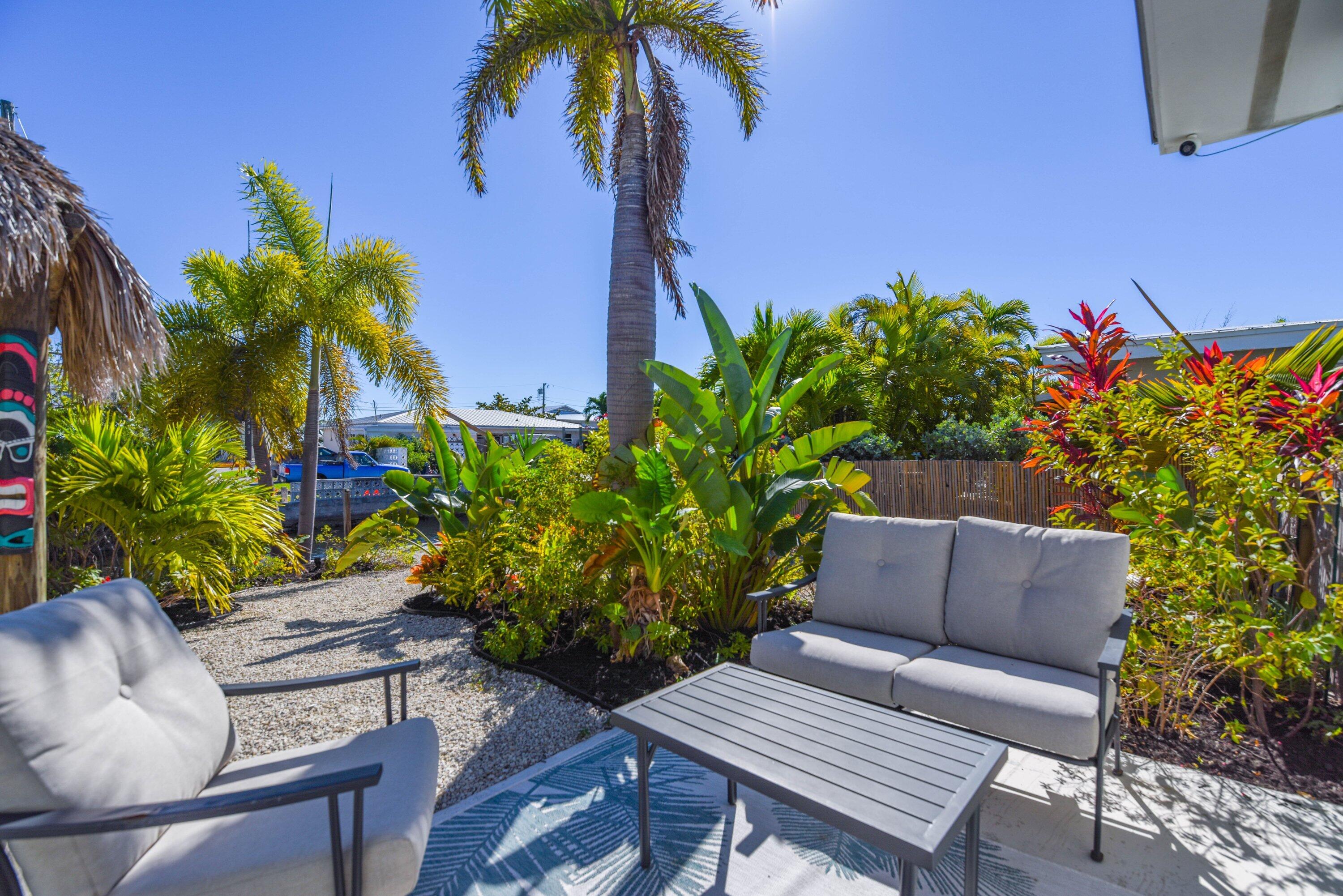 1567 Watson Boulevard Big Pine Key, FL 33043 - Photo 30 of 57 a backyard of a house with lots of green space and outdoor seating