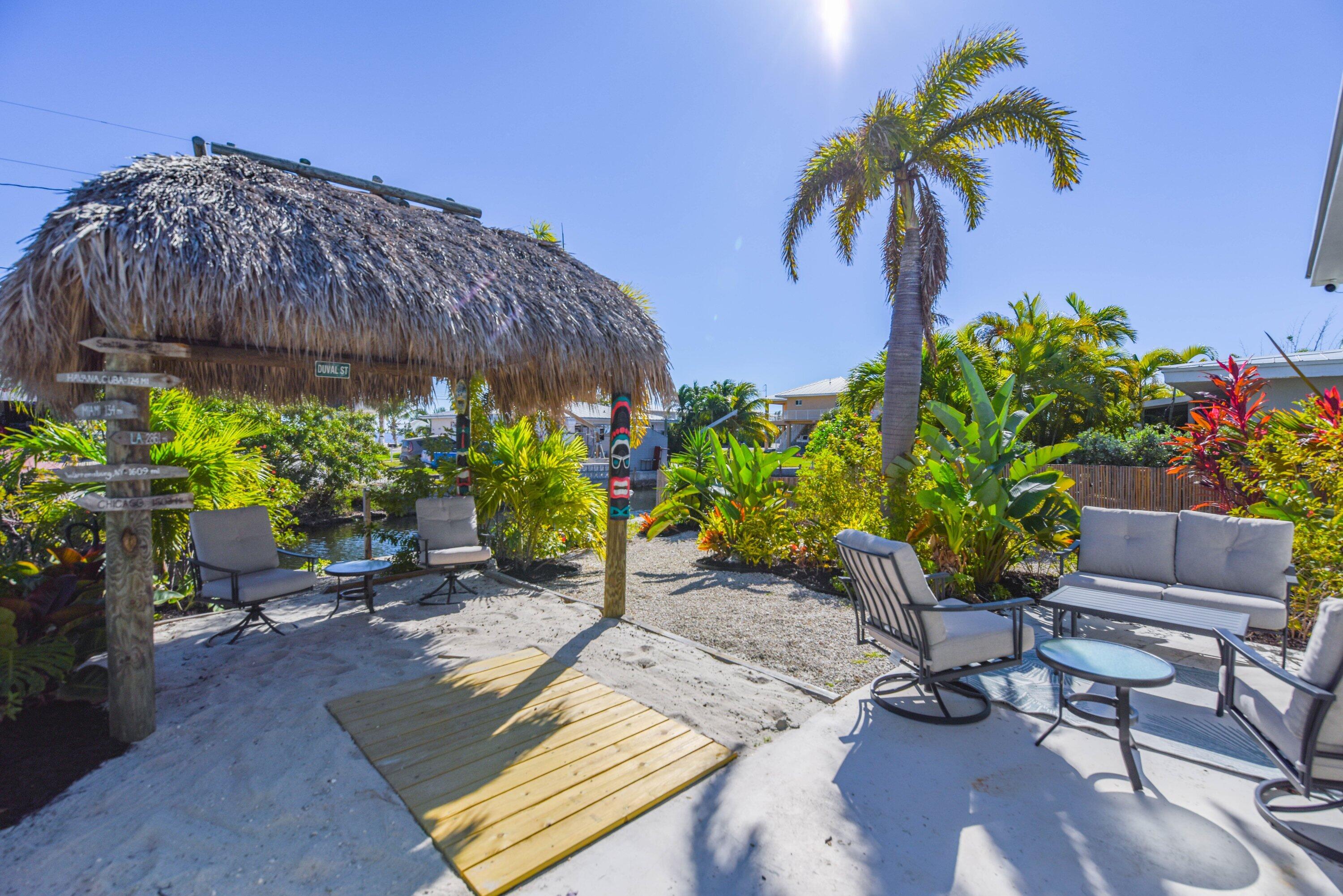 1567 Watson Boulevard Big Pine Key, FL 33043 - Photo 33 of 57 a backyard of a house with lots of green space and outdoor seating