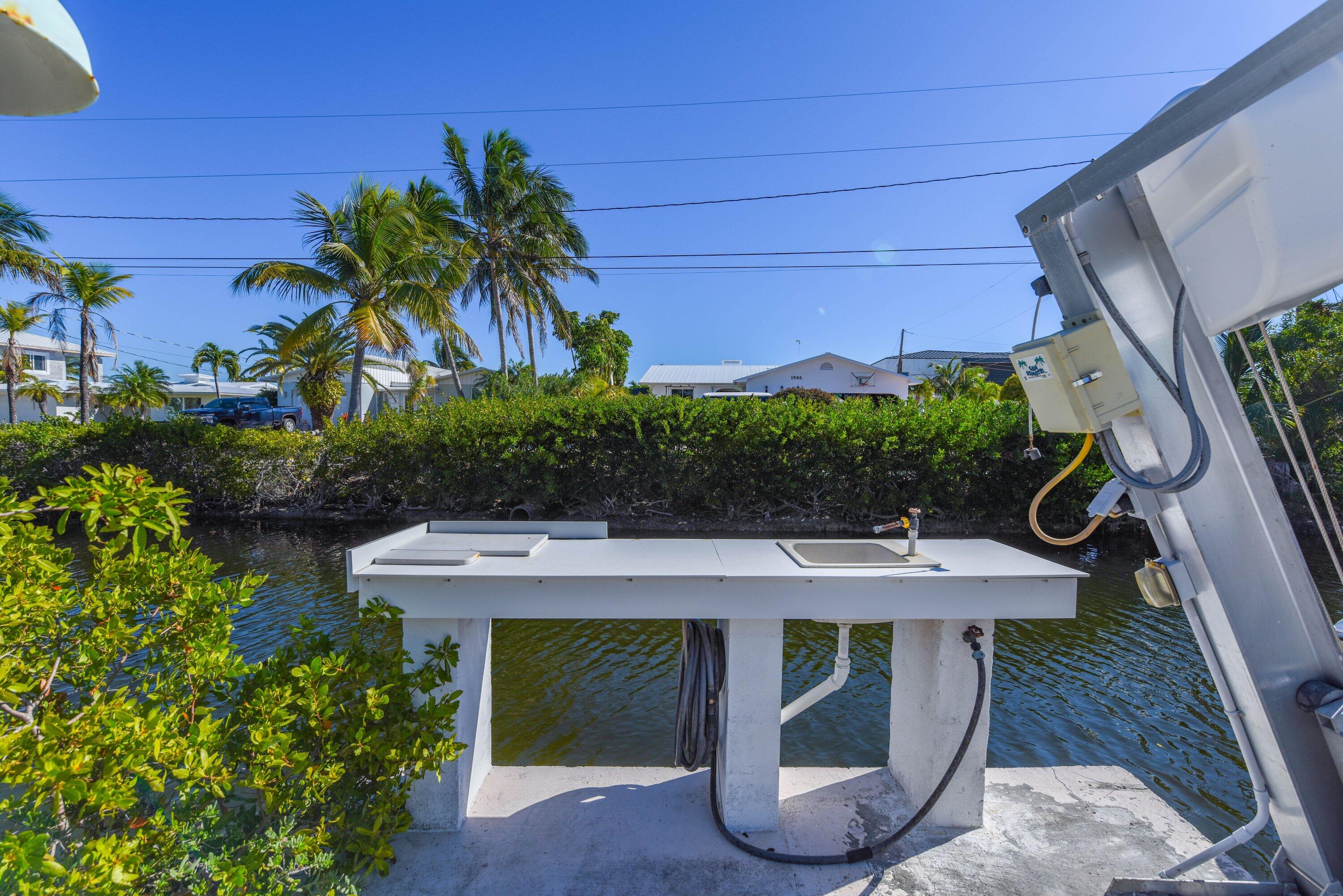1567 Watson Boulevard Big Pine Key, FL 33043 - Photo 43 of 57 a view of a patio with table and chairs potted plants with wooden floor