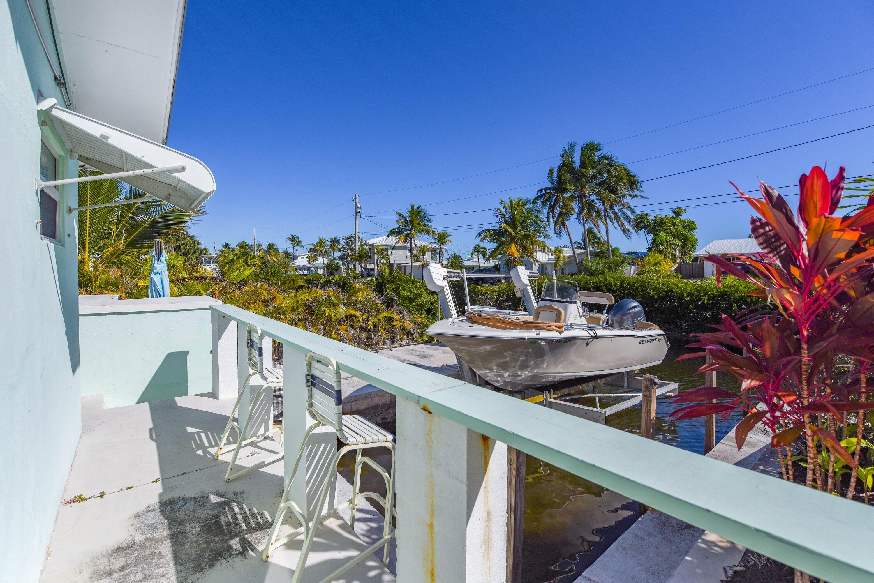 1567 Watson Boulevard Big Pine Key, FL 33043 - Photo 47 of 57 a view of a balcony with two chairs and a table