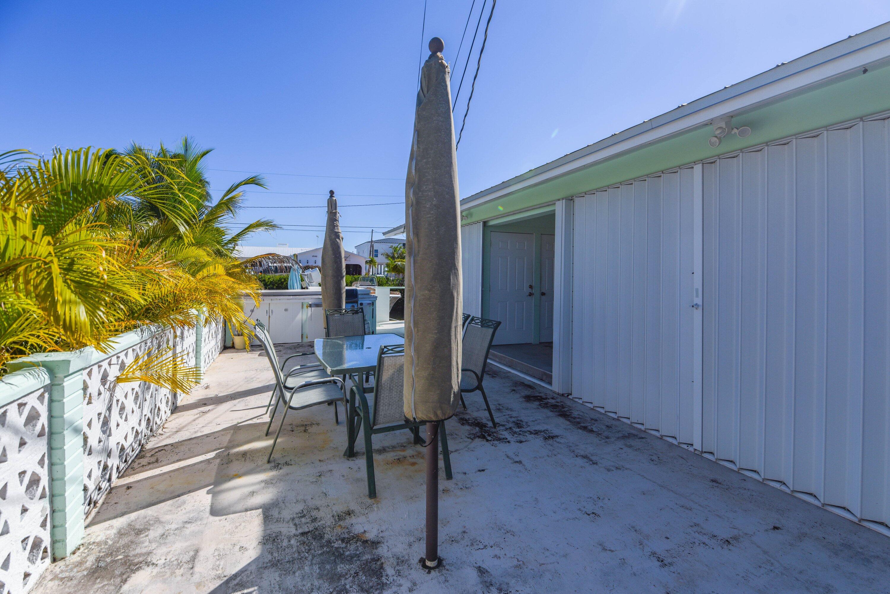 1567 Watson Boulevard Big Pine Key, FL 33043 - Photo 50 of 57 a view of a patio with a table and chairs