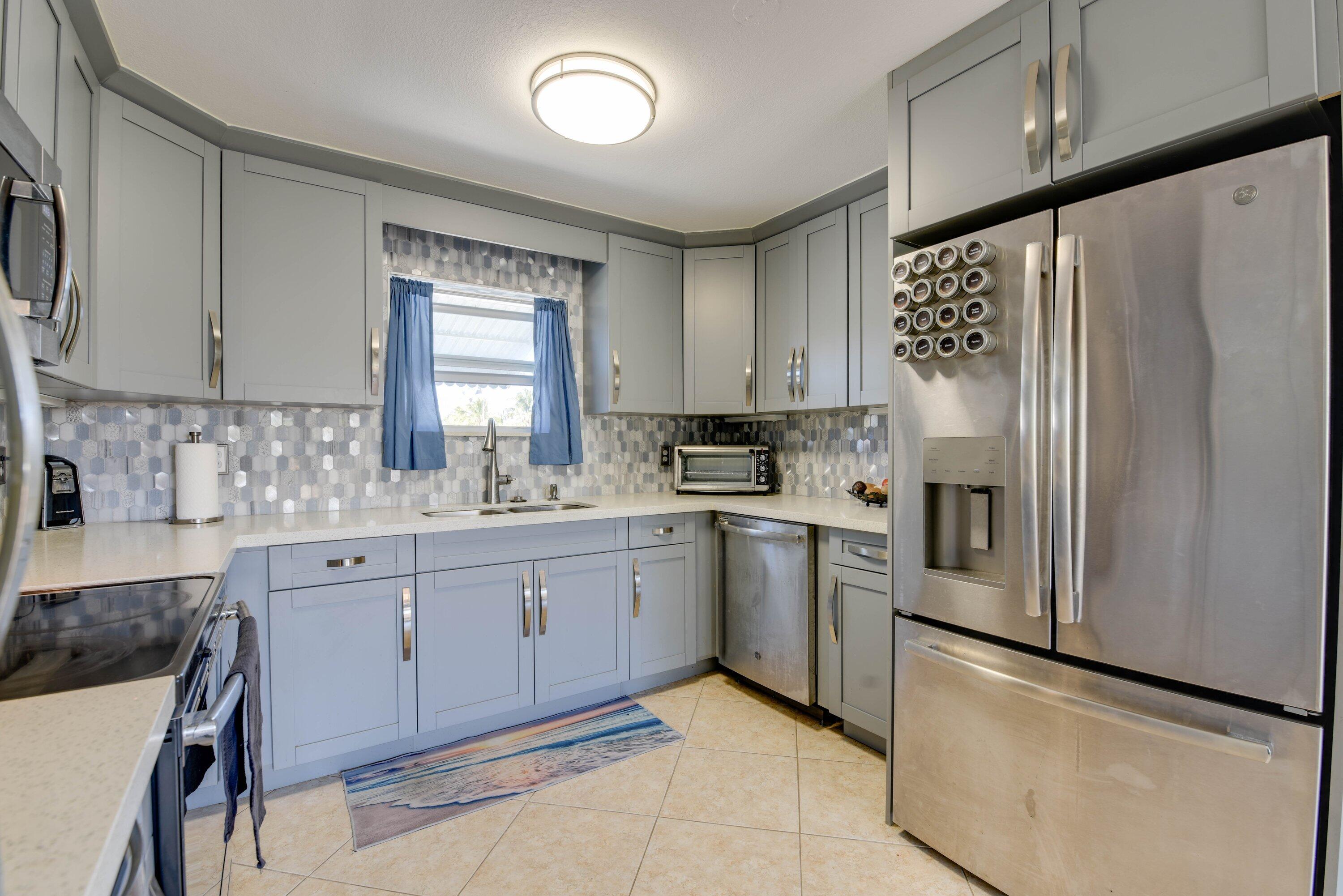 1567 Watson Boulevard Big Pine Key, FL 33043 - Photo 9 of 57 a kitchen with granite countertop white cabinets white stainless steel appliances a sink and a window