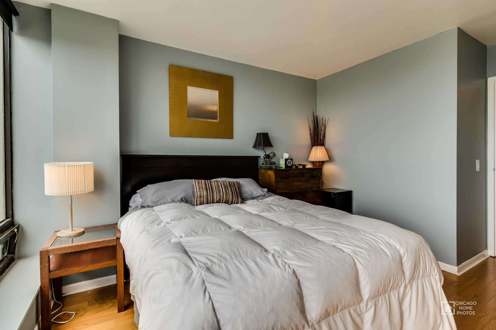 5445 North Sheridan Road, Unit 1809 Chicago, IL 60640 - Photo 12 of 18 a bedroom with a bed and wooden floor
