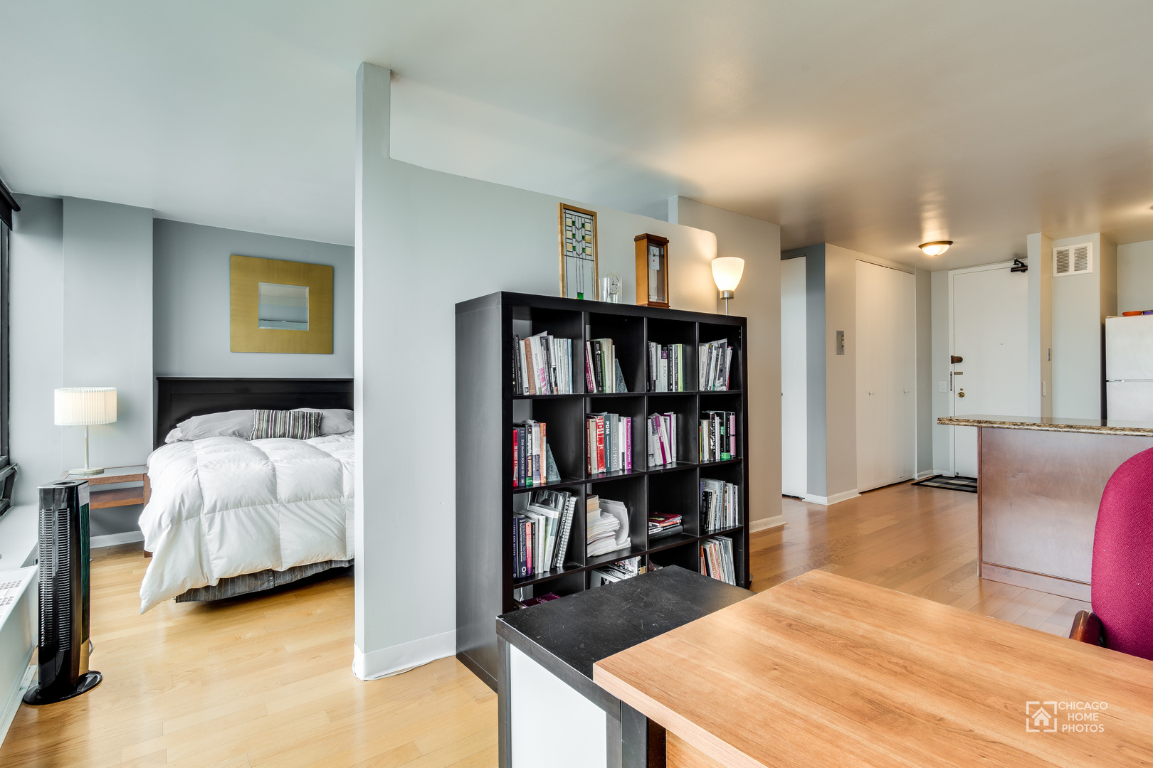 5445 North Sheridan Road, Unit 1809 Chicago, IL 60640 - Photo 4 of 18 a bedroom with a bed furniture and a book shelf