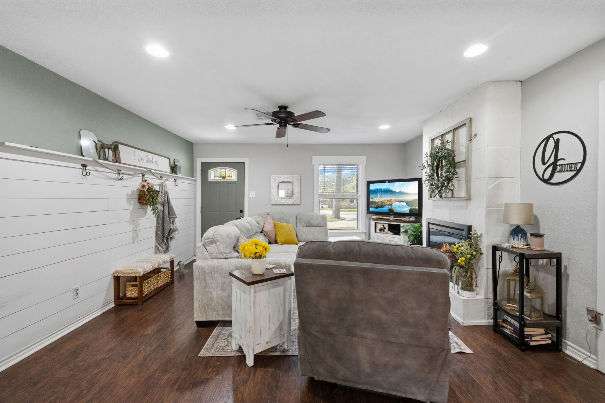 431 Corydon Drive Houston, TX 77336 - Photo 6 of 26 Alternate view of the family room showcasing its flexible layout with ample space for a variety of living arrangements. Laminate wood floors, recessed lighting, and a ceiling fan enhance comfort, while a striking shiplap accent wall adds warmth and character.