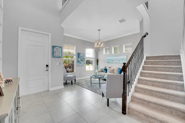 a kitchen with stainless steel appliances a stove a sink a refrigerator white cabinets and chairs