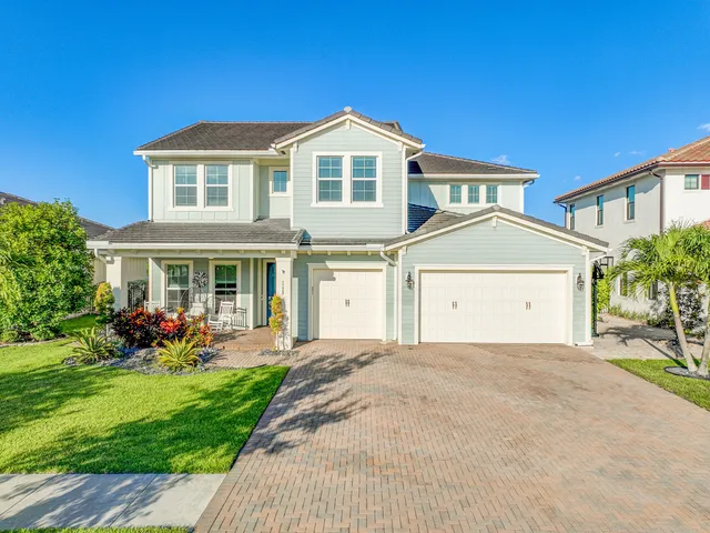 a front view of a house with a yard and potted plants