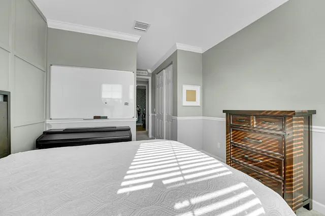 a bedroom with a bed and a flat screen tv in white walls