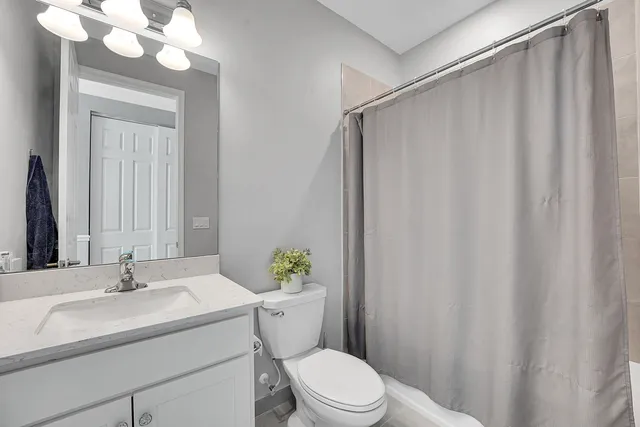 a bathroom with a sink mirror vanity and toilet