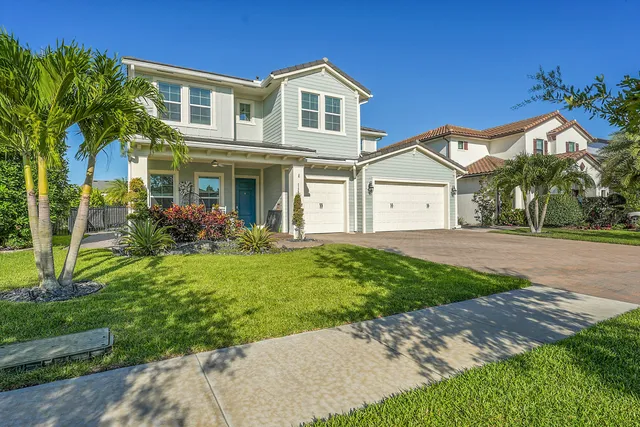 a front view of a house with a yard and potted plants