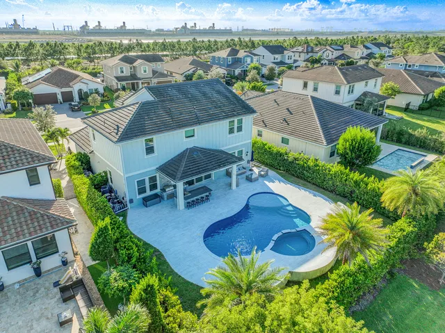 an aerial view of a house with yard swimming pool and ocean view