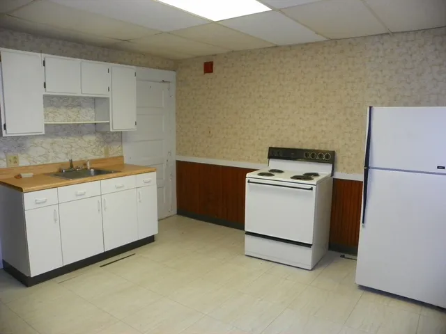 a kitchen with white cabinets and white appliances
