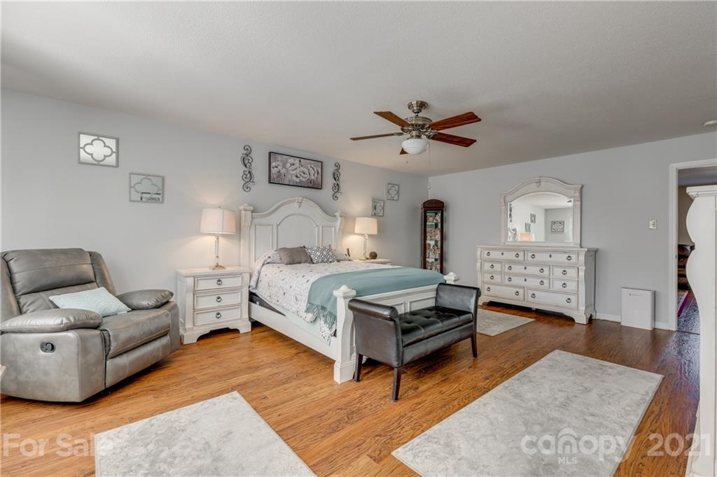 199 Old Carriage Road Clover, SC 29710 - Photo 33 of 48 a bedroom with a bed a couch and a chandelier