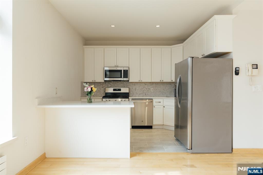 30 Park Avenue, Unit 2 Rutherford, NJ 07070 - Photo 11 of 31 a kitchen with a refrigerator a stove top oven and white cabinets