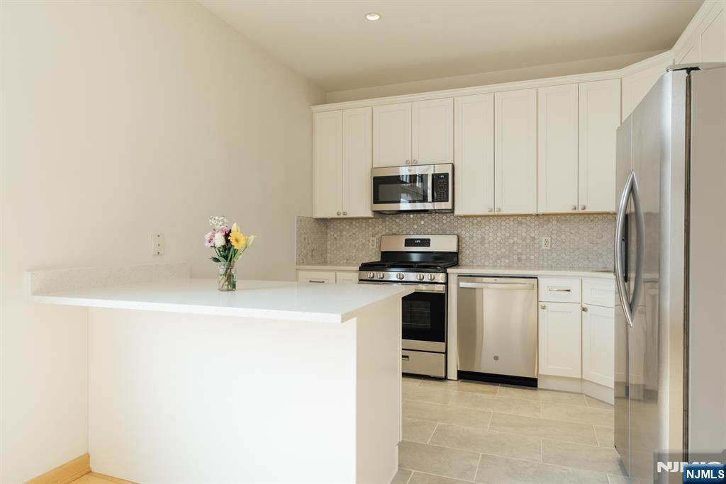 30 Park Avenue, Unit 2 Rutherford, NJ 07070 - Photo 13 of 31 a kitchen with stainless steel appliances a stove a microwave a sink a refrigerator a window