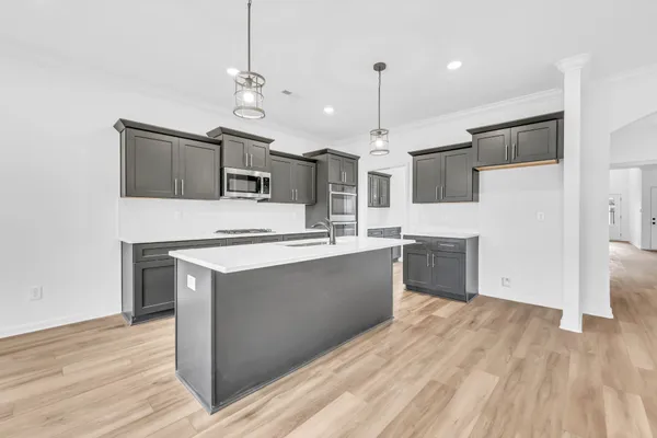 a large kitchen with stainless steel appliances kitchen island granite countertop a sink and a stove
