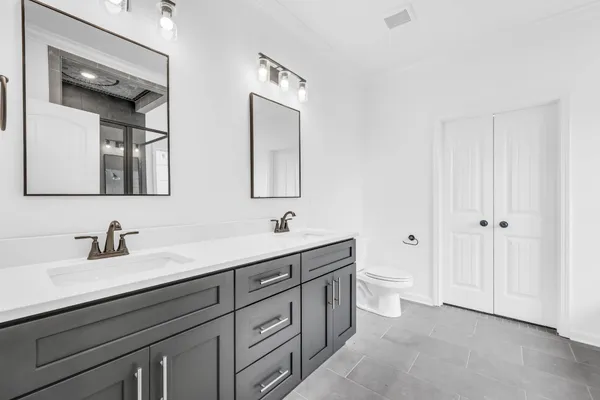 a bathroom with a toilet a sink a mirror and