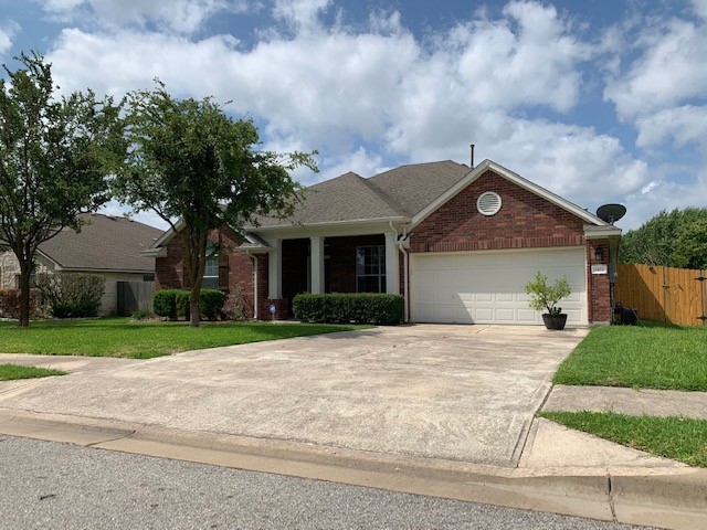 1103 Pigeon Forge Road Pflugerville, TX 78660 - Photo 1 of 1 a front view of a house with a yard and garage