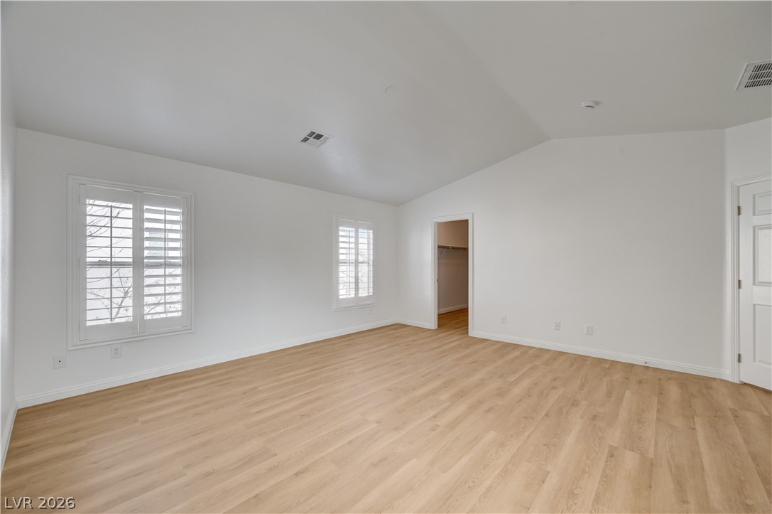 8918 Houston Ridge Avenue Las Vegas, NV 89178 - Photo 20 of 35 A tranquil primary bedroom with vaulted ceilings and beautiful wood flooring awaits you.