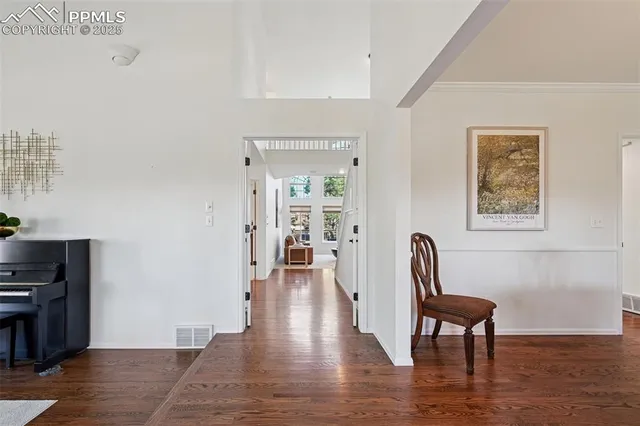 a view of a hallway with wooden floor and furniture