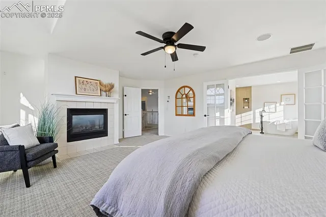 a spacious bedroom with a bed and a fireplace