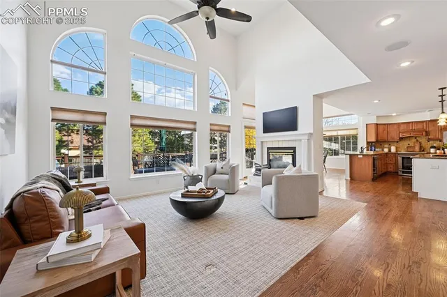 a living room with fireplace furniture and a large window