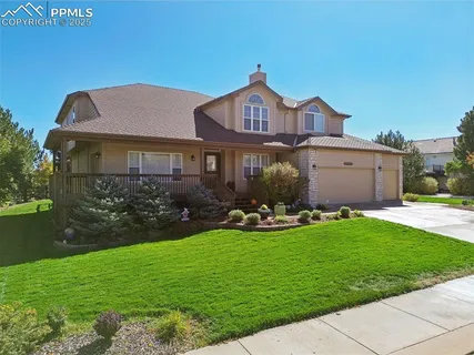 a front view of a house with garden and yard