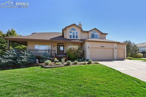 a backyard of a house with yard table and chairs