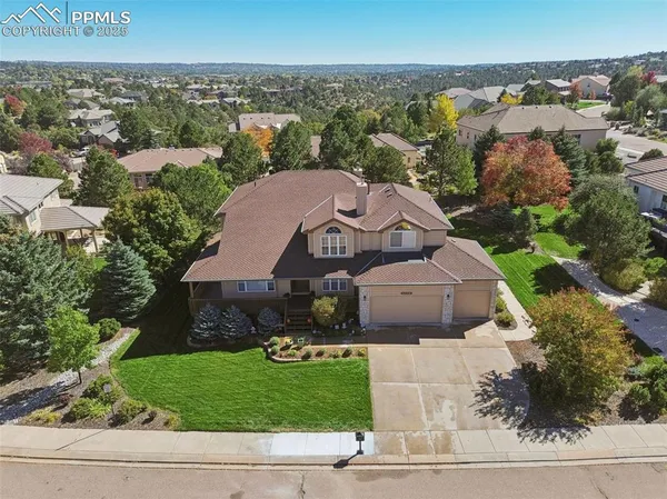 an aerial view of a house with a garden and lake view