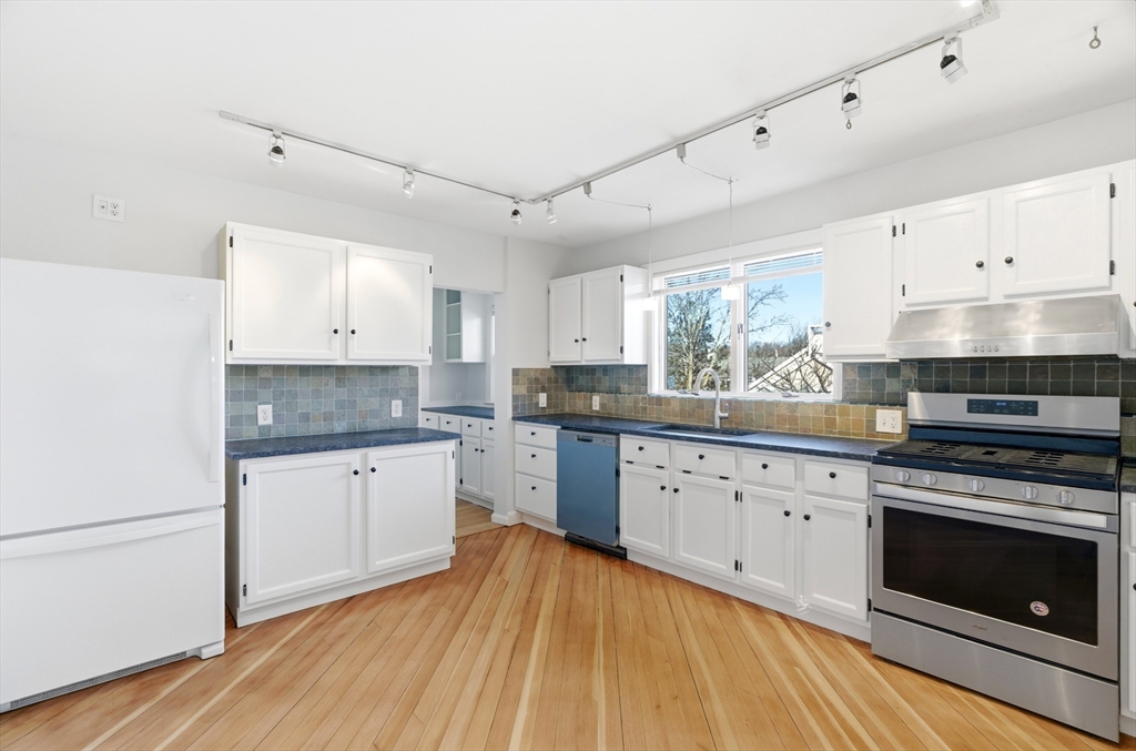 a kitchen with granite countertop white cabinets and white appliances