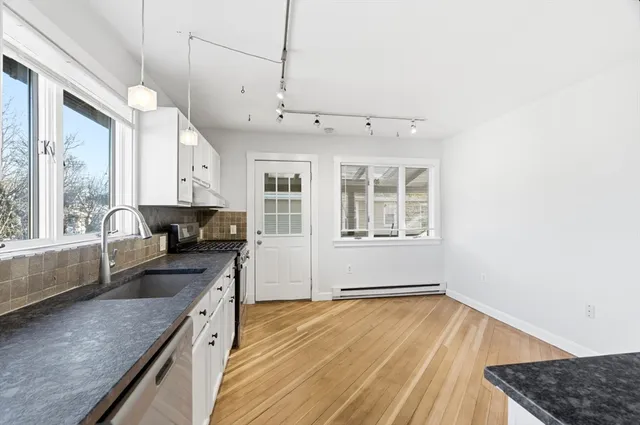 a kitchen with granite countertop a stove and a sink