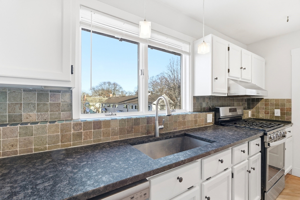 29-31 Edward T Sullivan Road, Unit 2 Cambridge, MA 02138 - Photo 12 of 34 a kitchen with granite countertop a sink a counter top space and cabinets
