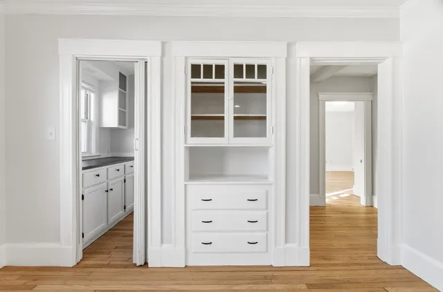 an empty room with cabinet and wooden floor