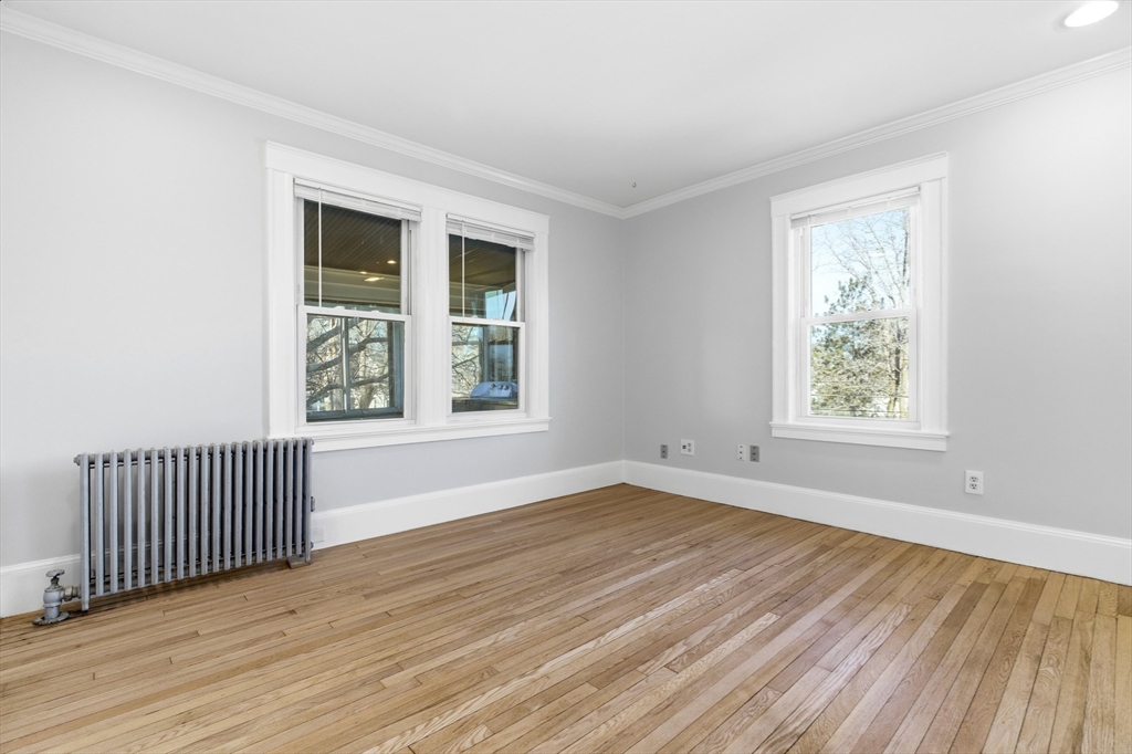 29-31 Edward T Sullivan Road, Unit 2 Cambridge, MA 02138 - Photo 6 of 34 an empty room with wooden floor and windows
