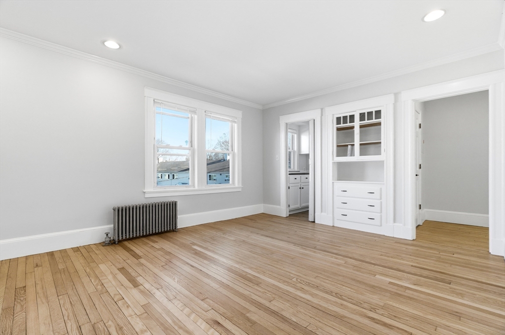 29-31 Edward T Sullivan Road, Unit 2 Cambridge, MA 02138 - Photo 7 of 34 an empty room with wooden floor and windows