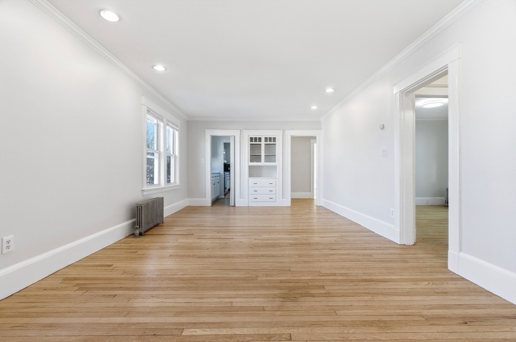 29-31 Edward T Sullivan Road, Unit 2 Cambridge, MA 02138 - Photo 8 of 34 a view of an empty room with wooden floor and a window