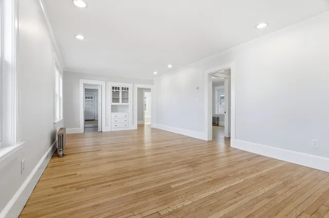 a view of an empty room with wooden floor