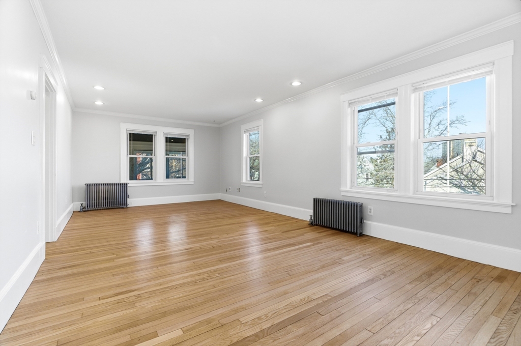 29-31 Edward T Sullivan Road, Unit 2 Cambridge, MA 02138 - Photo 10 of 34 an empty room with wooden floor and windows