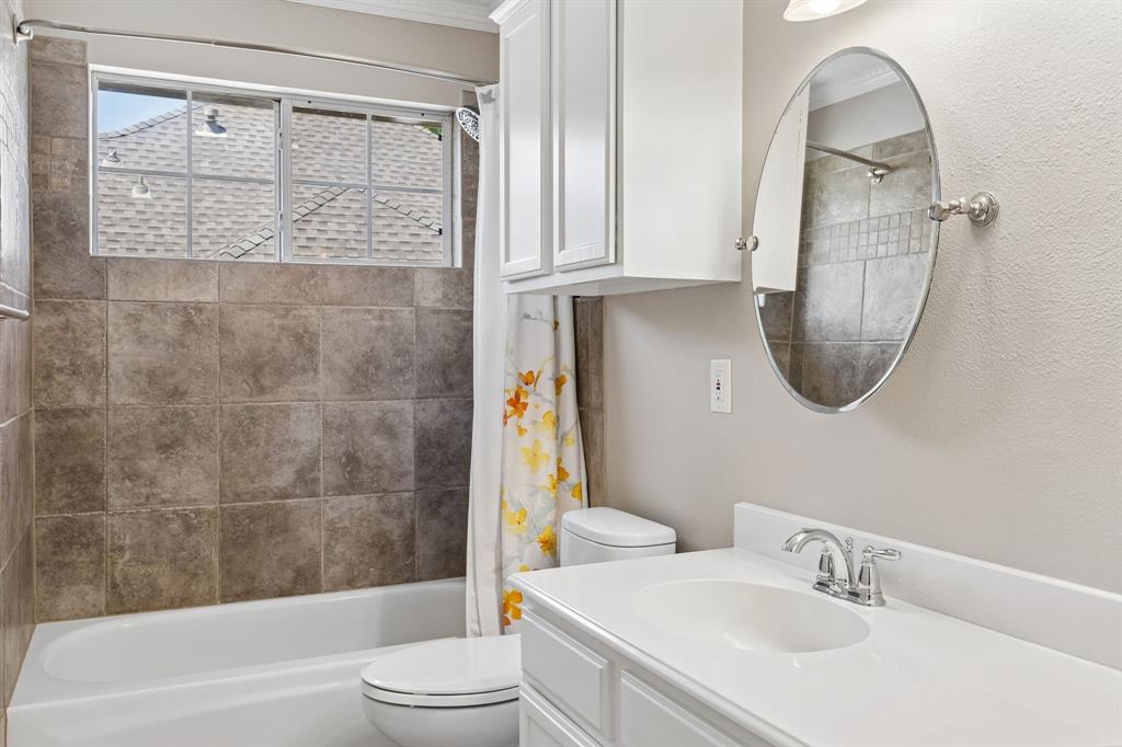 2925 Sunset Ridge McKinney, TX 75072 - Photo 18 of 33 Well-appointed upstairs secondary bathroom featuring tiled tub and shower surrounds, updated fixtures, bright natural light, and clean timeless finishes designed for comfort and functionality.